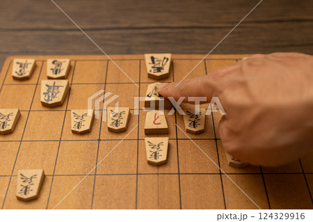 将棋盤と将棋の駒 王手をさしている人物の手元 将棋盤と将棋の駒 王手をさしている人物の手元 124329916