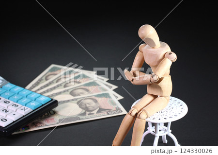 椅子に座る木製人形と1万円札と計算機 椅子に座る木製人形と1万円札と計算機 124330026