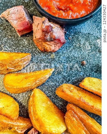 Pork steak with potato wedges and salsa sauce. High quality photo Pork steak with potato wedges and salsa sauce. High quality photo 124330427