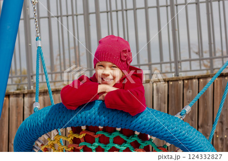 Caucasian smiling child of 8 9 years swinging on round seesaw 124332827