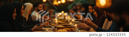 Muslim families and friends sharing iftar dinner during ramadan under ornamental lanterns 124333335