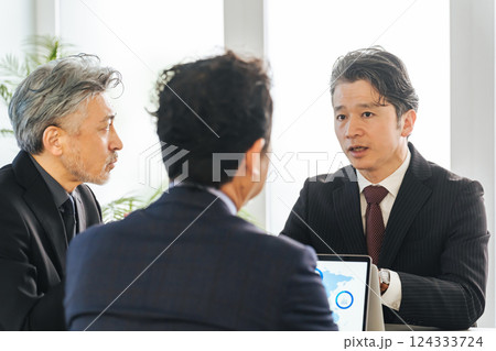 会議室でミーティングするミドルエイジ男性ビジネスパーソンのグループ 124333724