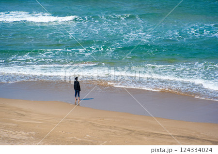 浜辺に佇む少年 124334024