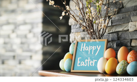 Happy Easter wooden sign, vivid Easter eggs, spring twigs on wooden fireplace shelf, gray rock wall. Happy Easter wooden sign, vivid Easter eggs, spring twigs on wooden fireplace shelf, gray rock wall. 124334603