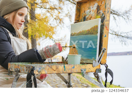 Child painting autumn landscape on canvas Child painting autumn landscape on canvas 124334637