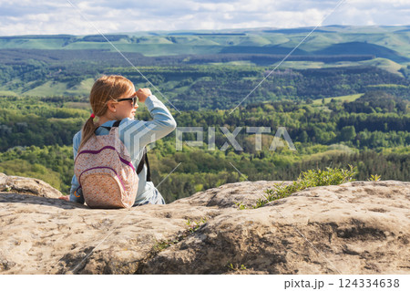 Child hiker shielding eyes while enjoying scenic mountain view in spring Child hiker shielding eyes while enjoying scenic mountain view in spring 124334638