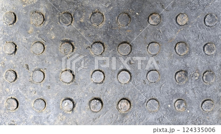 Close-up of steel metal cover texture, rough and rustic finish, low relief dot, grey color tone for background design. Close-up of steel metal cover texture, rough and rustic finish, low relief dot, grey color tone for background design. 124335006