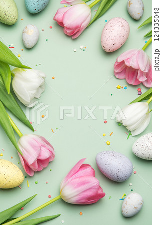 Easter eggs and tulips forming a frame on a pastel green background Easter eggs and tulips forming a frame on a pastel green background 124335048