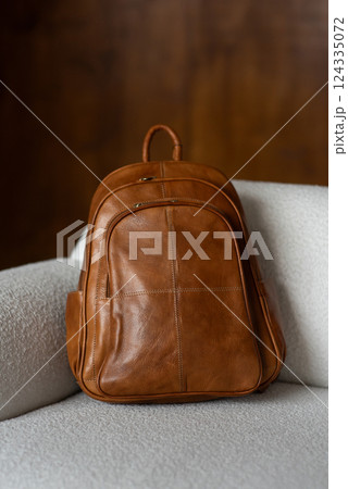 Brown leather backpack on a sofa 124335072