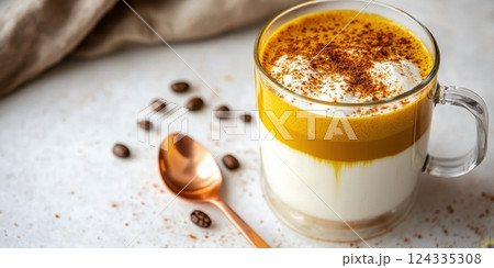 Creamy dalgona coffee in glass cup with cinnamon and coffee beans on table 124335308