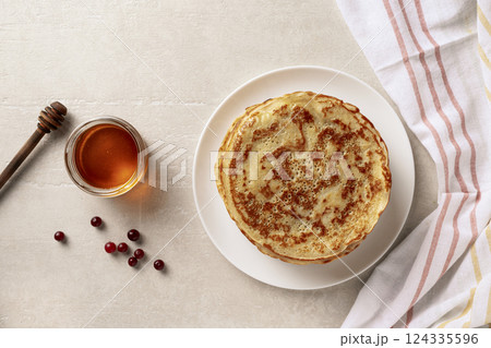 Crepes thin pancakes with honey on a white plate Crepes thin pancakes with honey on a white plate 124335596
