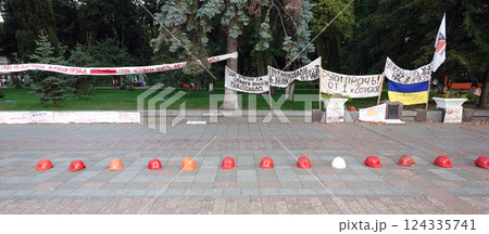 Kiev, Ukraine September 26, 2020: Workers' helmets lined up in a square in protest Kiev, Ukraine September 26, 2020: Workers' helmets lined up in a square in protest 124335741