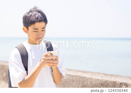 スマホを見ながら場所を探す少年 スマホを見ながら場所を探す少年 124338340