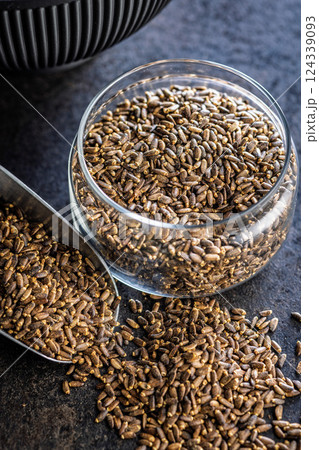 Milk thistle seeds in jar on black table. Milk thistle seeds in jar on black table. 124339093