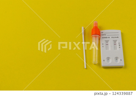 COVID-19 and flu testing kit on a bright yellow background COVID-19 and flu testing kit on a bright yellow background 124339887