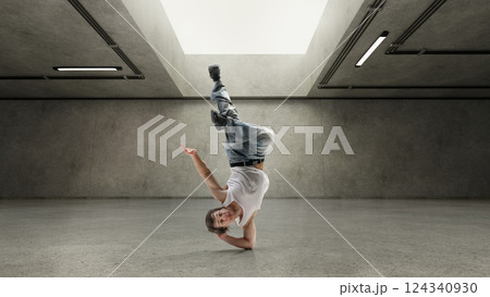 Smiling dancer balanced on head with leg raised, frozen in playful hip-hop pose under soft light against grey concrete walls. Handmade collage. 124340930