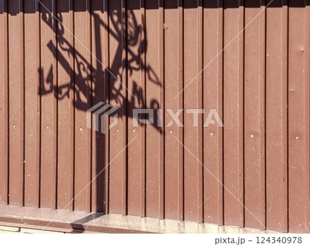 Texture of modern metallic brown fence with weathervane shadow outline 124340978