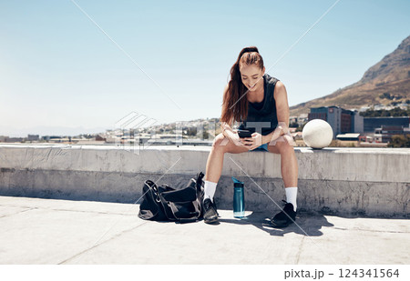 Sports woman, phone and football or soccer workout on city building rooftop for break or rest with 5g network service for app or social media. Female athlete after fitness exercise outdoor with ball 124341564