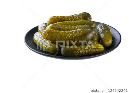pickled cucumbers on a black plate isolated on a white background. 124342241