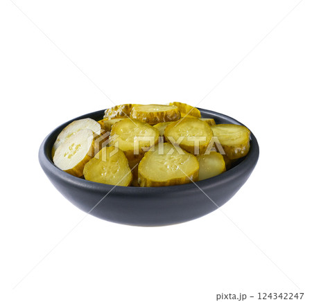 chopped pickled cucumbers in a black bowl isolated on a white background. 124342247
