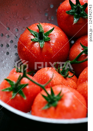 Close up of ripe red tomatoes with water drops on metal colander Close up of ripe red tomatoes with water drops on metal colander 124342743