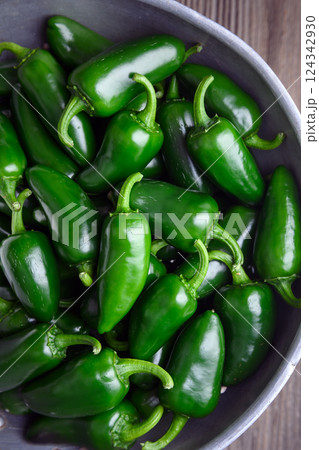 Top view on metal colander filled with green jalapeno peppers 124342930