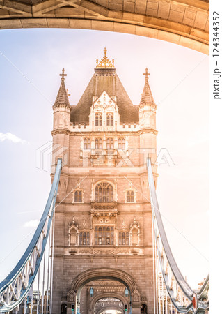 Tower Bridge stands majestically in London, showcasing its ornate architecture and iconic towers. Sunlight casts a warm glow, highlighting the beauty of this historic landmark. 124344352
