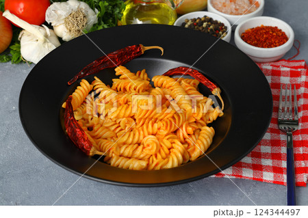 Fusilli pasta in tomato sauce. gray background. Italian food concept Fusilli pasta in tomato sauce. gray background. Italian food concept 124344497