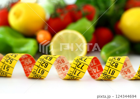 diet concept with measuring tape . fresh vegetables on a white background. Selective focus. diet concept with measuring tape . fresh vegetables on a white background. Selective focus. 124344694