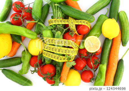 diet concept with measuring tape . fresh vegetables on a white background. Selective focus. diet concept with measuring tape . fresh vegetables on a white background. Selective focus. 124344696