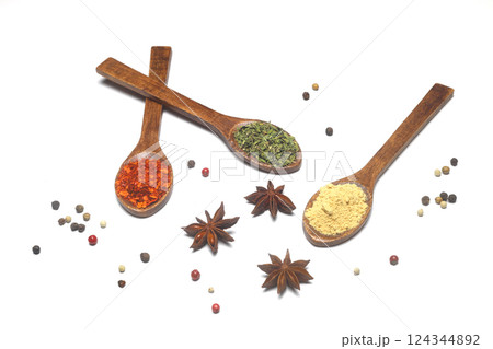 Different kind of spices on a white background. Oriental spices in spoons, red peppers, curry powder, cinnamon powder, mint powder, colorful peppers. Flat lay, top view. Different kind of spices on a white background. Oriental spices in spoons, red peppers, curry powder, cinnamon powder, mint powder, colorful peppers. Flat lay, top view. 124344892
