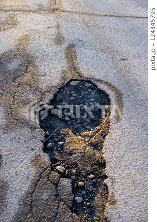 potholes in the road, holes in the asphalt on the roadway or highway. potholes in the road, holes in the asphalt on the roadway or highway. 124345795