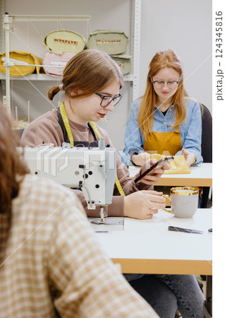 Three women sew in workshop at clothing factory. industrial equipment sewing machines. Three women sew in workshop at clothing factory. industrial equipment sewing machines. 124345816