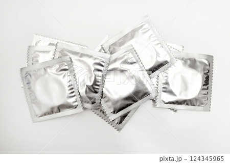 Condoms in shiny packaging on a white background. Contraceptives for men. Condoms in shiny packaging on a white background. Contraceptives for men. 124345965