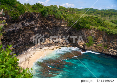 Cliff broken by wave of ocean formed perfect paradise untouched beach. Natural azure bathing pool in the rock. Angel's Billabong is popular tourist destination on island of Nusa Penida in Indonesia. 124346052