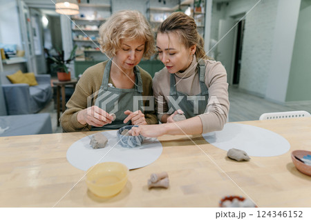 Senior student enjoys a pottery course, proving lifelong learning has no age limit. Active aging concept, elderly woman explores artistic skills, finding fulfillment in ceramics 124346152