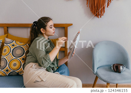 A professional musician reads a printed score, preparing for a performance. A dedicated artist studies notation and harmony to improve her instrumental mastery 124346155