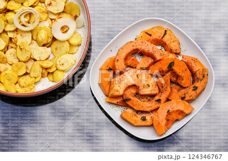Grilled potatoes and orange butternut squash pieces on two plates - top down view Grilled potatoes and orange butternut squash pieces on two plates - top down view 124346767