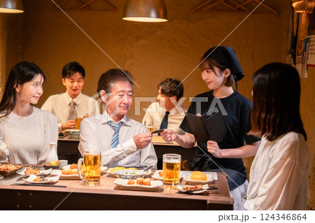 居酒屋でキャッシュレス決済をする男性客 居酒屋でキャッシュレス決済をする男性客 124346864