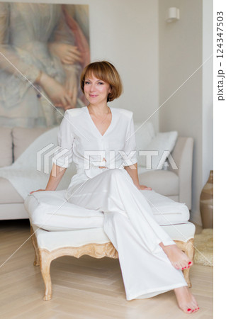 Beauty woman sitting at stylish bright living room and looking at camera. 124347503