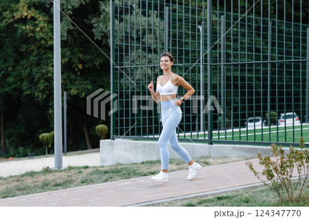Young sportswoman running in the park enjoying her workout 124347770