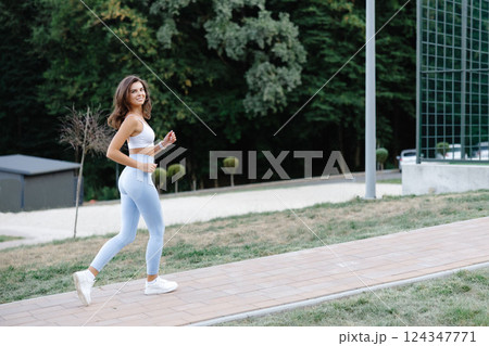 Young sportswoman running in the park enjoying her workout 124347771