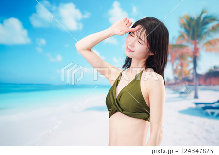 青空のビーチで水着を着た若い女性 124347825