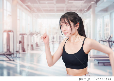 ジムでランニングをする若い女性 124348353
