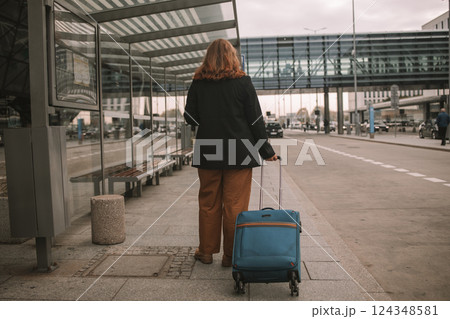 Traveler businesswoman with suitcase calling mobile phone waiting taxi on road in city street. Charming girl moves near airport with luggage. Traveler businesswoman with suitcase calling mobile phone waiting taxi on road in city street. Charming girl moves near airport with luggage. 124348581