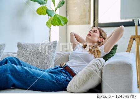 Happy relaxed serene young woman sitting at home on the couch 124348787