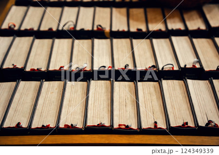 Antique books in a church, neatly stacked with bookmarks. Historical ambiance. The warm tones and Antique books in a church, neatly stacked with bookmarks. Historical ambiance. The warm tones and 124349339