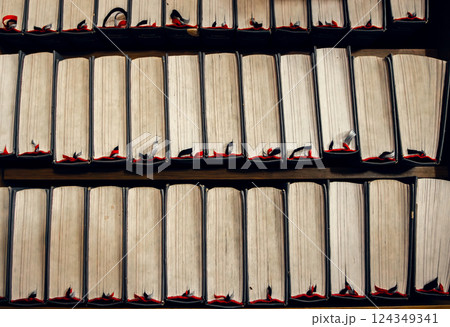 Stacked vintage books with worn edges and bookmarks, top view. Warm tones, academic and literary 124349341