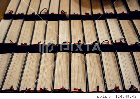Row of antique books with worn pages and ribbon bookmarks in a historical library. Perfect for 124349345