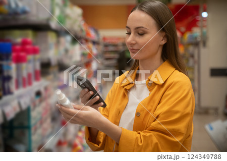 Scanning household chemicals in a grocery store aisle for safe product choices Scanning household chemicals in a grocery store aisle for safe product choices 124349788